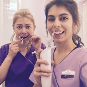 Chloe and Clarissa from New Street Dental Care struggling with floss but using the Phillips Air flosser