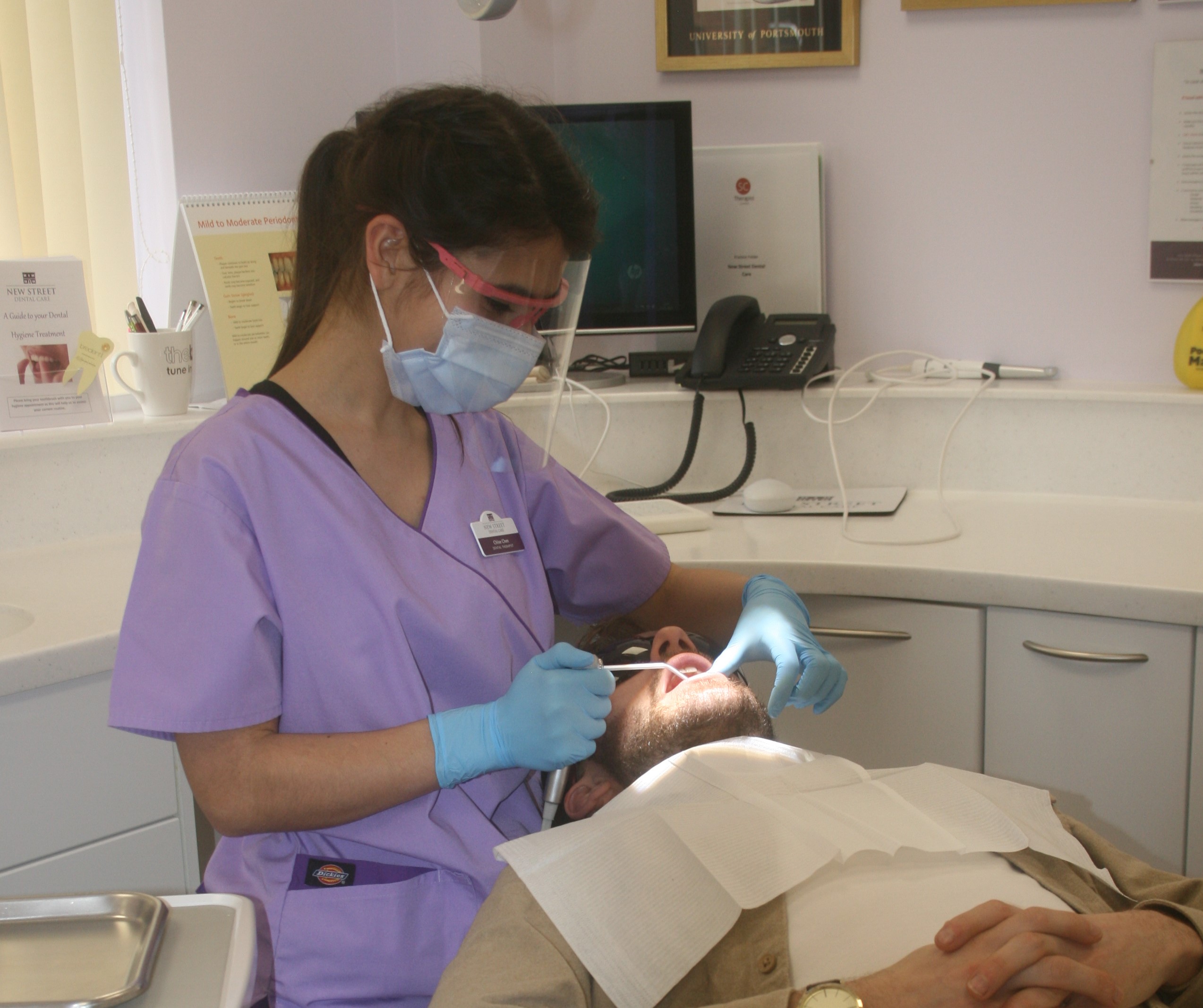 Chloe the dental hygienist treating a patient in the chair